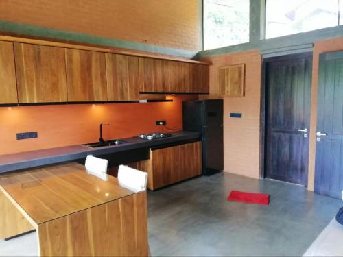 a kitchen with wooden cabinets and a red rug at Avera Hills Villas Unawatuna in Unawatuna