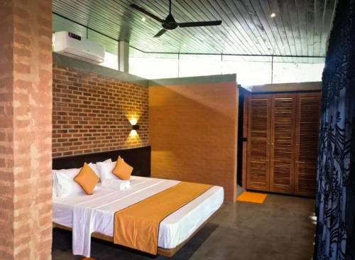 a bedroom with a bed and a brick wall at Avera Hills Villas Unawatuna in Unawatuna