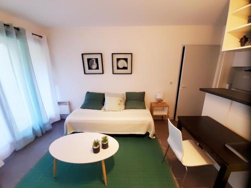 une chambre avec un lit, une table et un piano dans l'établissement La Marina avec Parking et accès Piscine, à La Rochelle