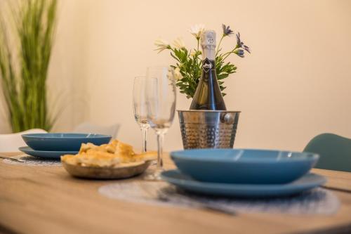 una mesa de madera con platos azules y copas de vino en ELEGANT HOUSE BY THE SEA RAPALLO - 50 meters from the beach ,near Portofino, en Rapallo