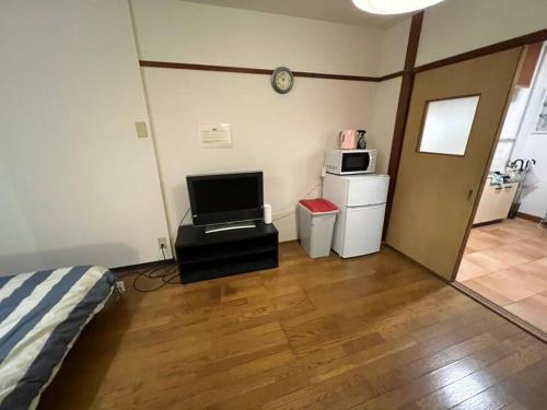 a room with a bed and a television and a microwave at Large two separated rooms in one room in Osaka