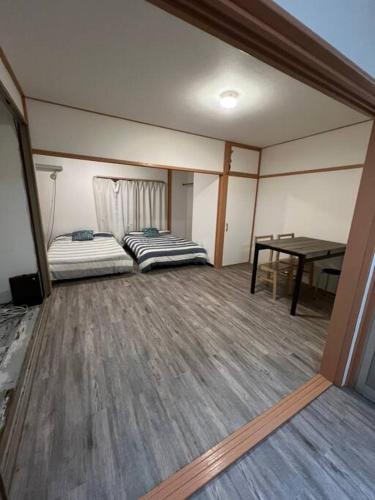 a room with two beds and a table in it at Large two separated rooms in one room in Osaka
