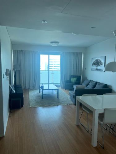 ein Wohnzimmer mit einem Sofa und einem Tisch in der Unterkunft Luxury private sea view room in Abu Dhabi