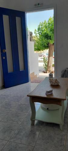 a table in front of a door with a blue door at Nostos in Patitiri