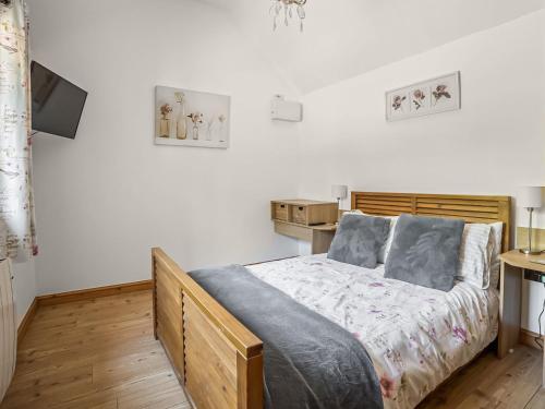 a bedroom with a bed and a television in it at Little Tree Cottage in Felmingham