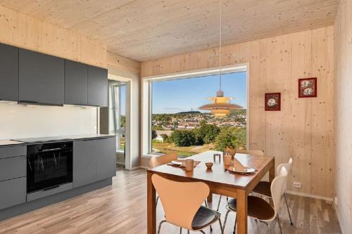 uma cozinha com mesa e cadeiras e uma grande janela em 7,3sq mts room -Forests cozy house em Stavanger
