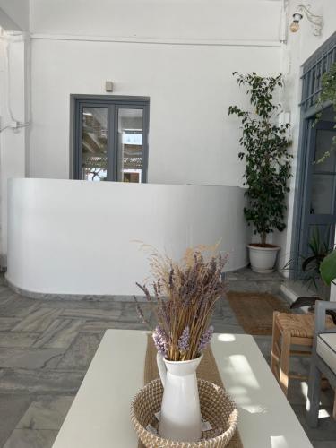 białą wazę siedzącą na stole na patio w obiekcie Kirki Rooms by the sea w mieście Parikia