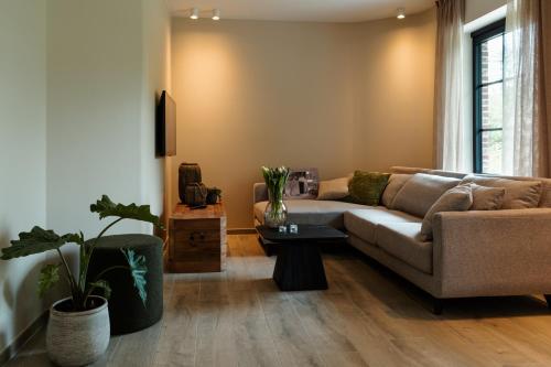 a living room with a couch and a table at Vakantiehoeve 'De Zandrug' in Stekene