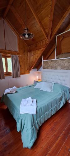 a large bed in a room with a wooden ceiling at Cabañas La Ufu in Golondrinas