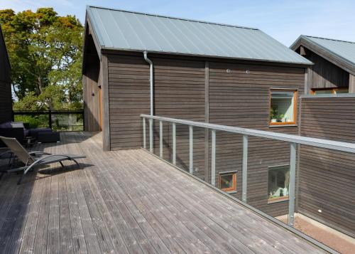 a large wooden deck with a house at Halltorp Townhouse in Borgholm