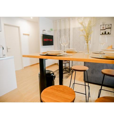 - une cuisine avec une table, des chaises et des verres à vin dans l'établissement #L'Estere WiFi-Netflix-Clim, à Eauze