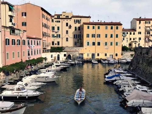 un grupo de barcos en un canal con edificios en Casa vacanze completa di tutto e anche di più, en Livorno