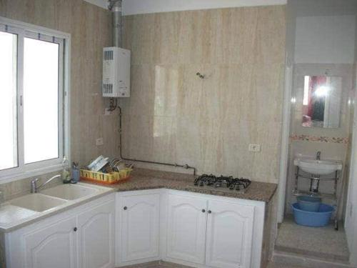 uma cozinha com um lavatório e uma bancada em Mahdia zone Touristique em Mahdia