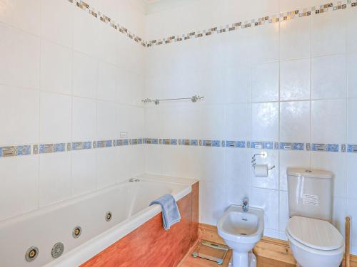 a bathroom with a tub and a toilet and a sink at 7 Roundham Heights in Paignton