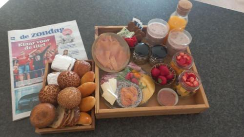 a tray of food with different foods and drinks at Vakantiehoeve 'De Zandrug' in Stekene