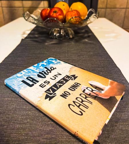 a book sitting on a table with a bowl of fruit at AL Ribeirinho in Mértola