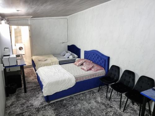- une chambre avec un lit bleu et deux chaises dans l'établissement Central rooms, à Chişinău