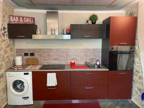 a kitchen with a washing machine and a washer at FONTANA’S HOUSE RELAX 13A in Valbravenna