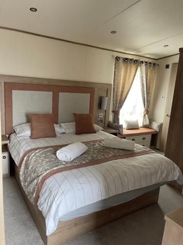 sypialnia z dużym łóżkiem i oknem w obiekcie 2-6 guests Holiday Home in Durdle Door w mieście Wareham