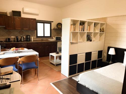 Habitación con cama y cocina con mesa en AL Ribeirinho, en Mértola