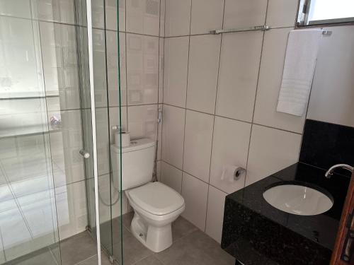 a bathroom with a toilet and a sink at Pousada dos Azevedo in Cláudio