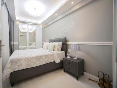 a bedroom with a large bed and a night stand at MAX 3+1 in Istanbul