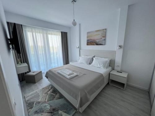 a bedroom with a bed and a large window at Apartament Hera Mamaia Nord in Năvodari