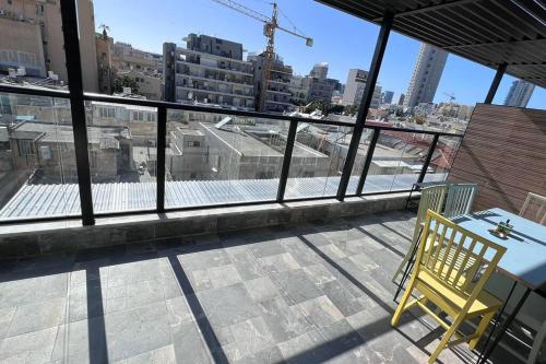 a balcony with a table and a chair on a building at New Large STUDIO flat in Tel Aviv 47 in Tel Aviv