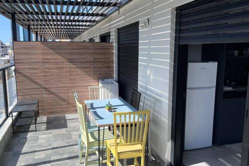 a patio with a table and chairs and a refrigerator at New Large STUDIO flat in Tel Aviv 47 in Tel Aviv