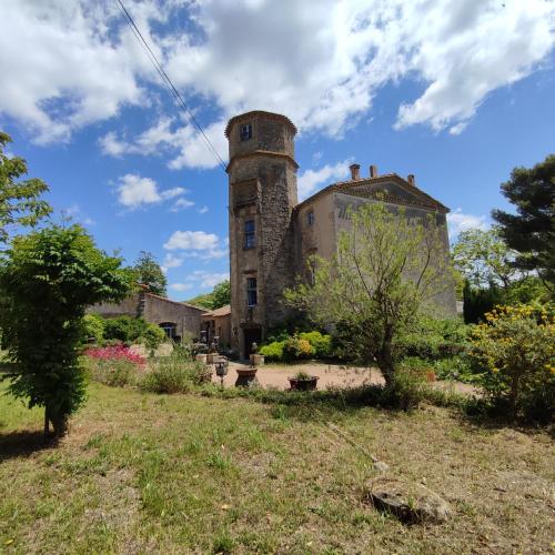 un antiguo edificio de piedra con una torre en un patio en Château Saint-Martin en Carcassonne