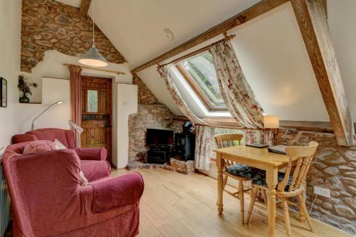 a living room with a wooden table and a couch at Duddings Country Cottages in Minehead