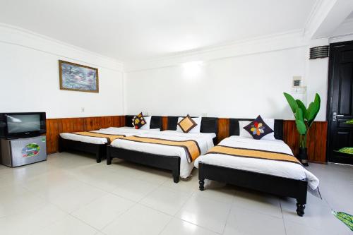 a room with three beds and a tv in it at Casablanca Hotel in Hue