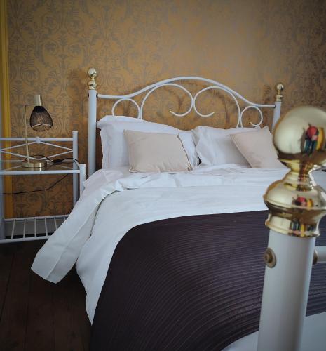 a white bed with white sheets and pillows at Château Saint-Martin in Carcassonne