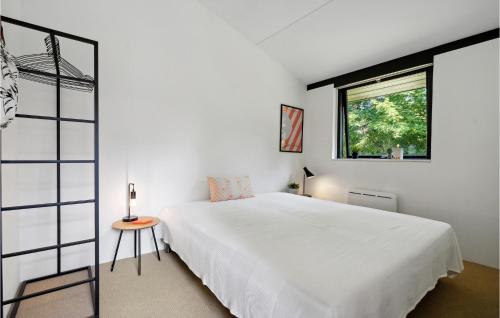 1 dormitorio con cama blanca y ventana en Awesome Home In Odder With Kitchen, en Odder