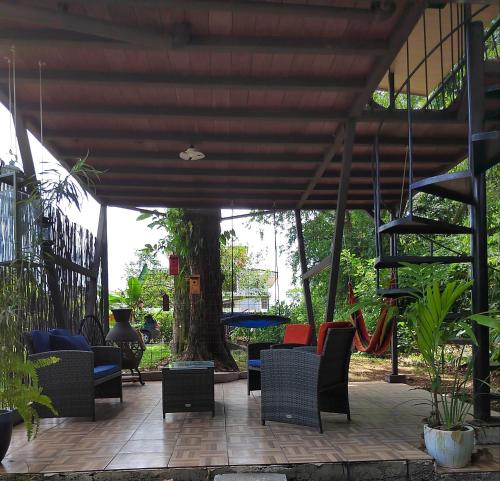 a patio with chairs and a tree and a staircase at Salamandra Costa Rica in Jiménez