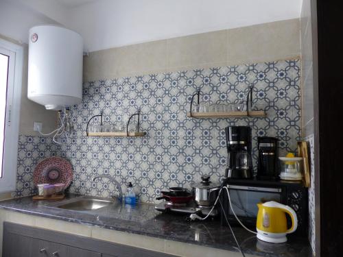 a kitchen with a sink and a counter top at EXCELLENT rapport Qualité Prix pour cet Appartement 3 étoiles 2P Tout Confort Clim Reversible Résidence Golf Mesnana Tanger in Tangier