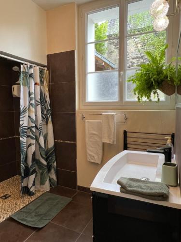 La salle de bains est pourvue d'une baignoire et d'une fenêtre. dans l'établissement Les Suites Angevines, à Angers