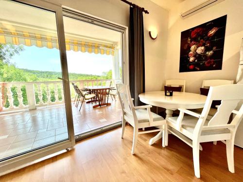 ein Esszimmer mit einem Tisch und Stühlen sowie einem Balkon in der Unterkunft Villa Theresa in Donji Zagon