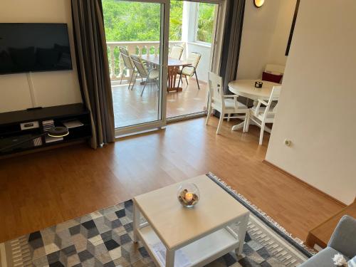 ein Wohnzimmer mit einem TV und einem Tisch mit Stühlen in der Unterkunft Villa Theresa in Donji Zagon