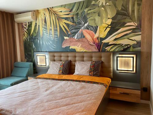una camera da letto con un letto grande con un dipinto sul muro di Hotel Atol a Sunny Beach