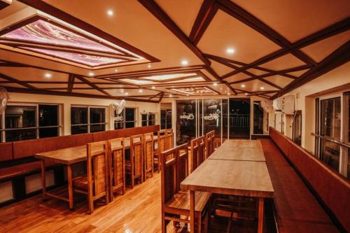 a dining room with wooden tables and chairs at Venice Premium Houseboats Alleppey in Alleppey