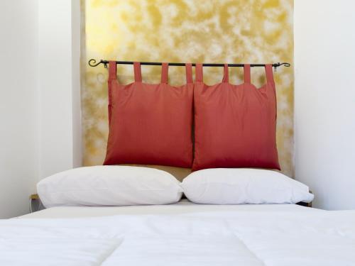 グラヴィーナ・イン・プーリアにあるGravina suite Apartmentのベッド1台(上に赤い枕2つ付)