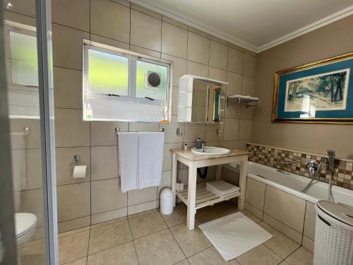 een badkamer met een wastafel, een toilet en een bad bij Seashelles Self-catering Apartment in Durban
