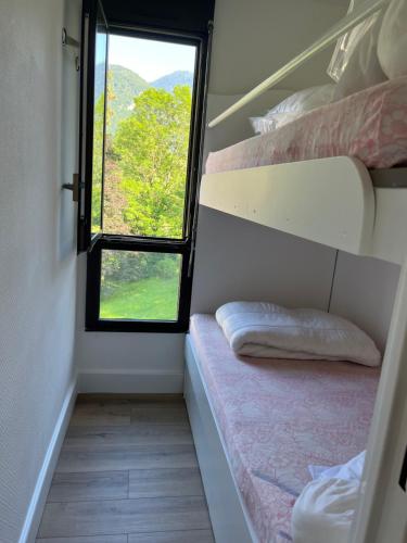 une petite chambre avec un lit et une fenêtre dans l'établissement STUDIO CABINE COSY À LUCHON, à Luchon