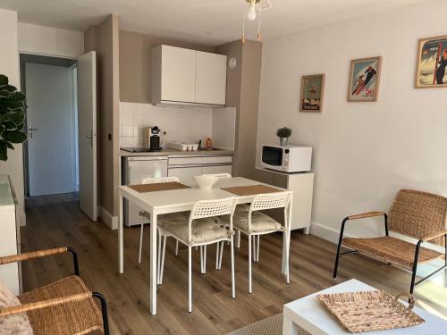 une cuisine et un salon avec une table et des chaises dans l'établissement STUDIO CABINE COSY À LUCHON, à Luchon