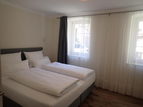 a bedroom with two beds and two windows at Karlbacher Domizil Ferienwohnungen in Großkarlbach