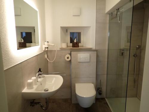 a bathroom with a toilet and a sink and a shower at Karlbacher Domizil Ferienwohnungen in Großkarlbach