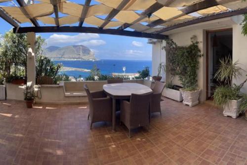 a patio with a table and chairs and a view of the ocean at La Scalinatella di Mondello in Palermo