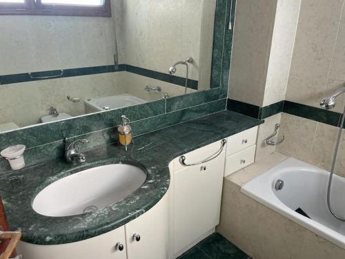 a bathroom with a sink and a tub and a mirror at La Scalinatella di Mondello in Palermo