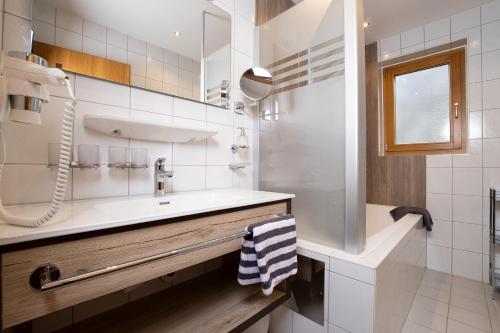 a white bathroom with a sink and a mirror at Appartement Rangger in Sölden